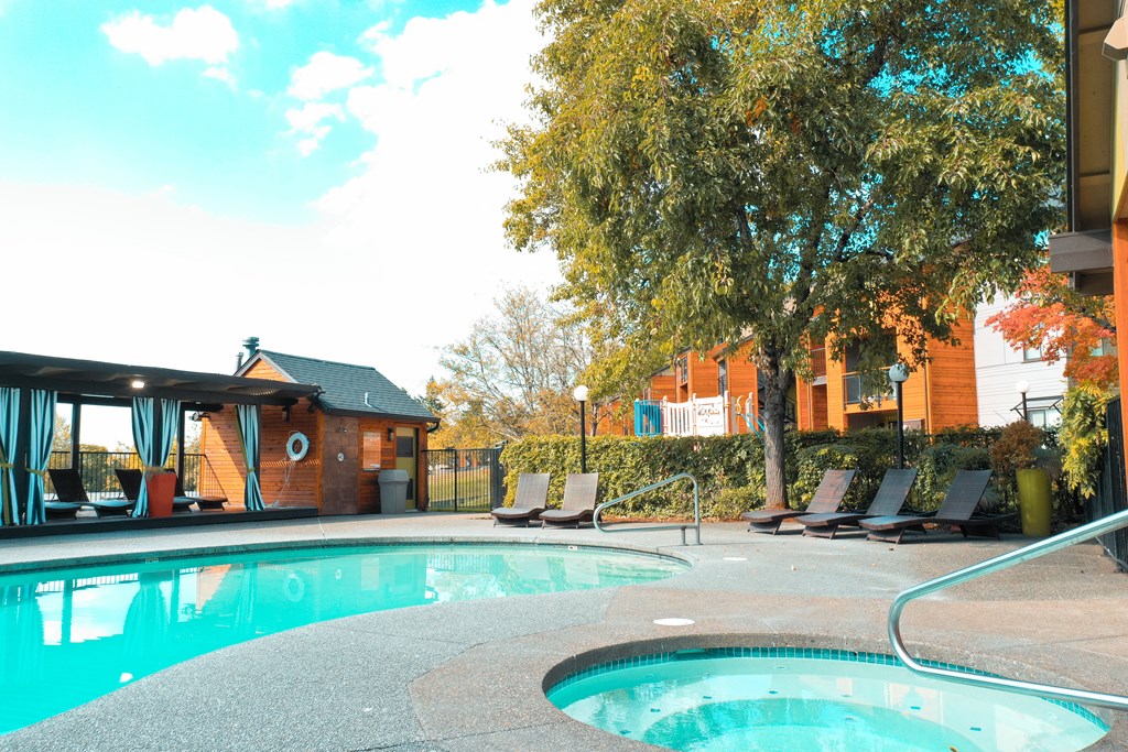 a swimming pool with chairs around it and a building in the background