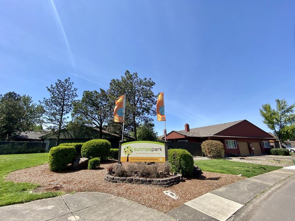 a view of the front of the summerhill park office building with flags flying in front of