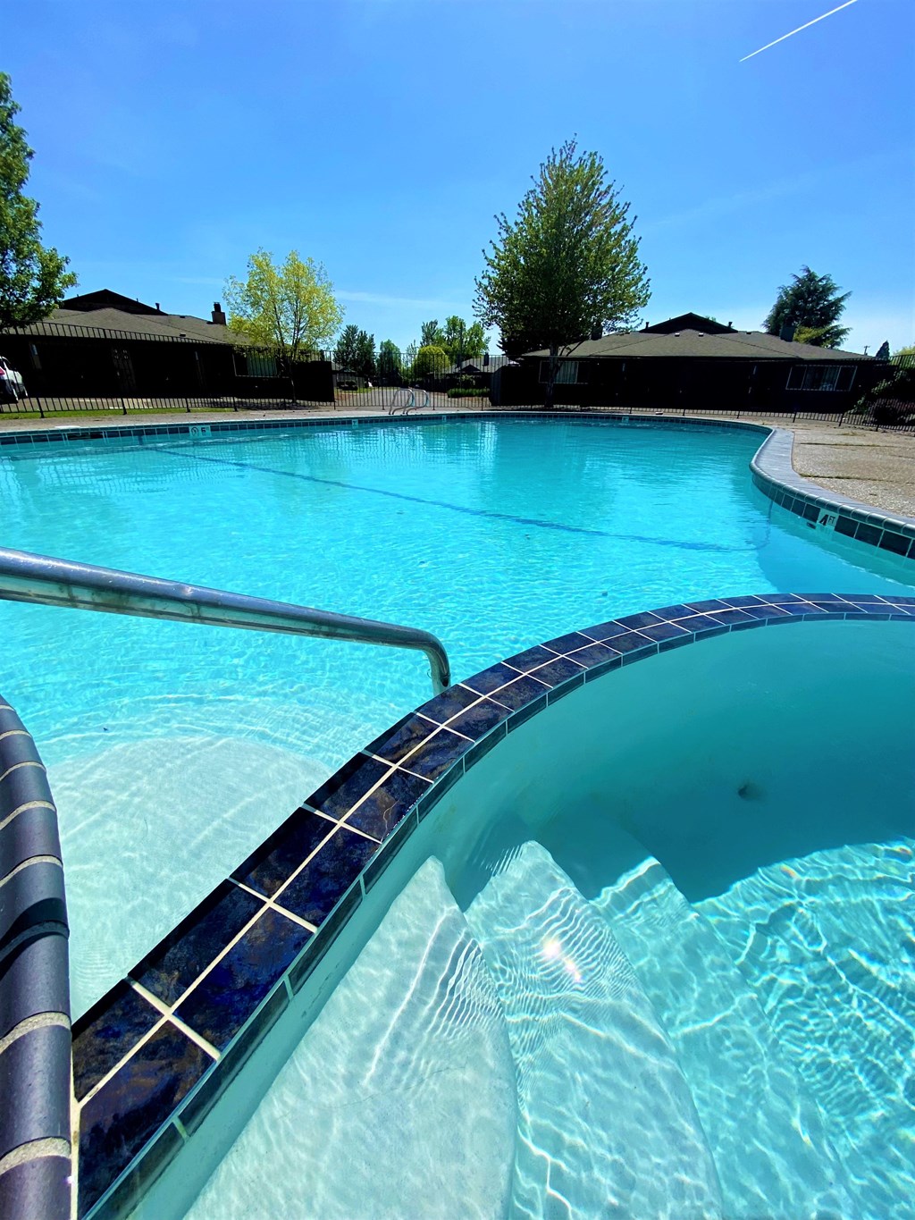 a large swimming pool with a blue sky in the background