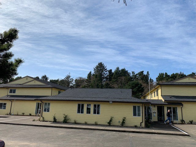 a yellow house with a blue sky in the background