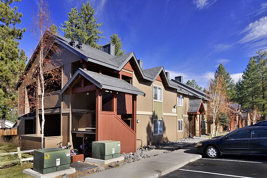 a row of townhomes with cars parked in front of them