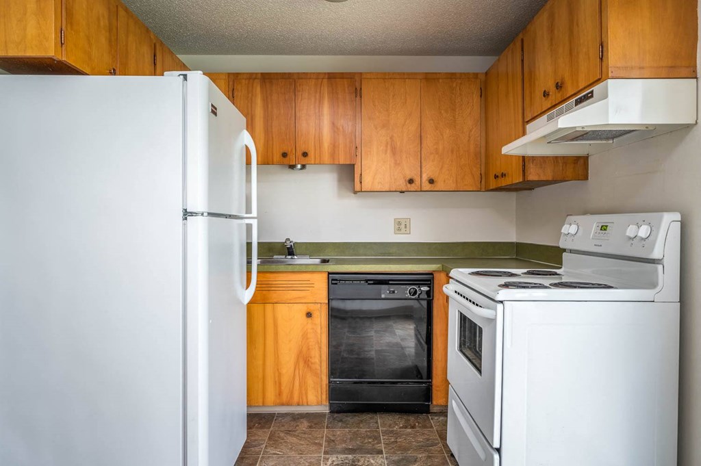 a kitchen with white appliances and wooden cabinets