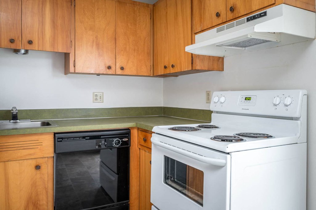 a kitchen with white appliances and wooden cabinets