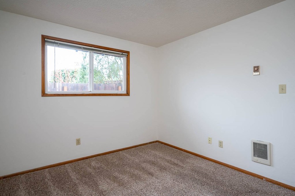 an empty bedroom with a large window
