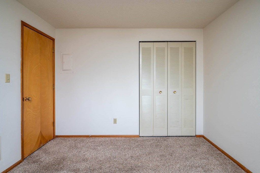 a bedroom with a closet and a door