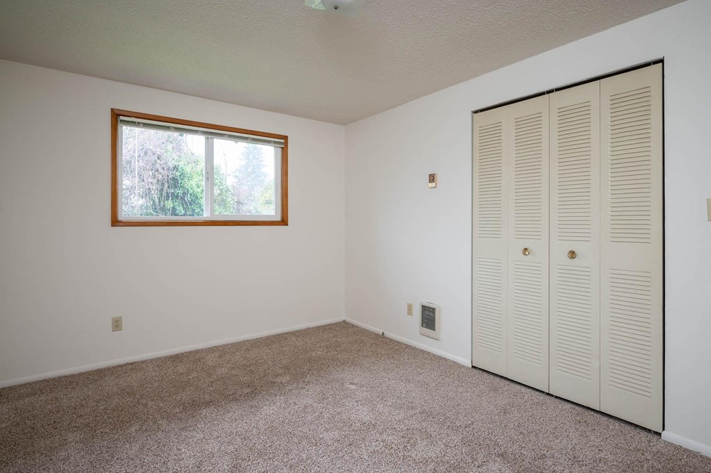 a bedroom with two closets and a window