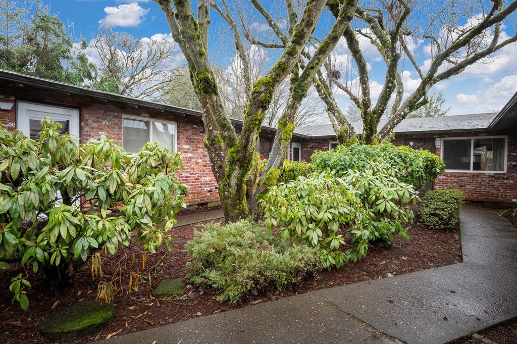 a brick house with a sidewalk in front of it