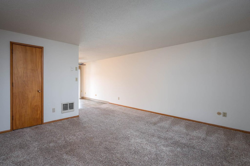 a bedroom with white walls and carpet