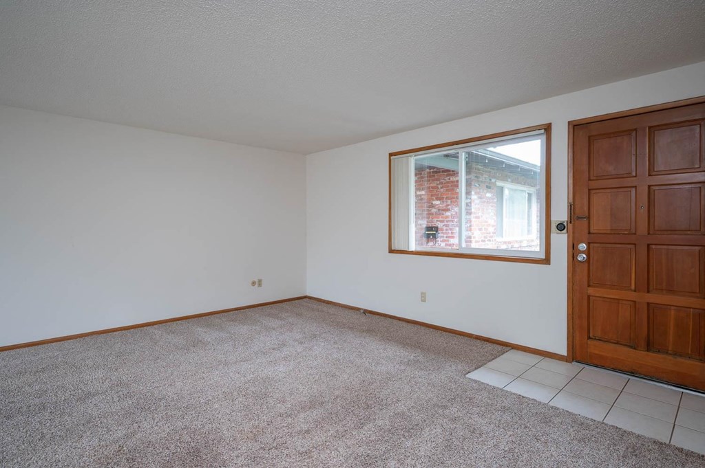 a bedroom with white walls and a large window