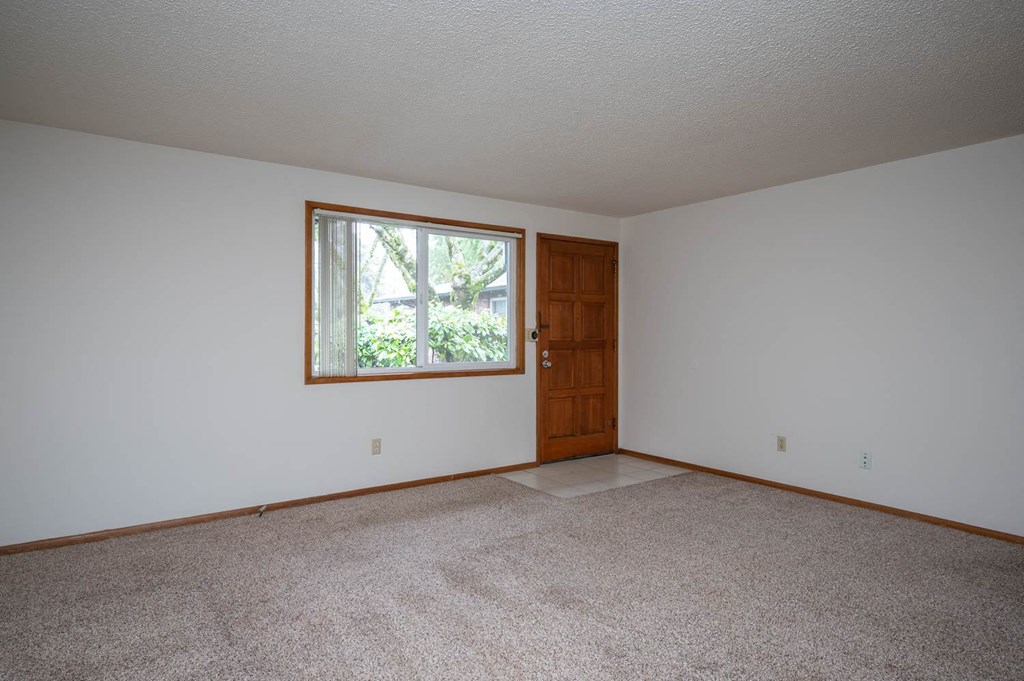 a large bedroom with white walls and a large window