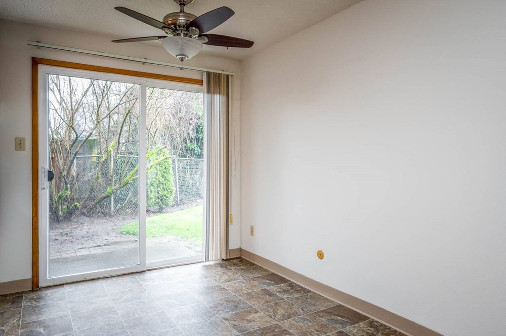 a bedroom with a sliding glass door and a ceiling fan