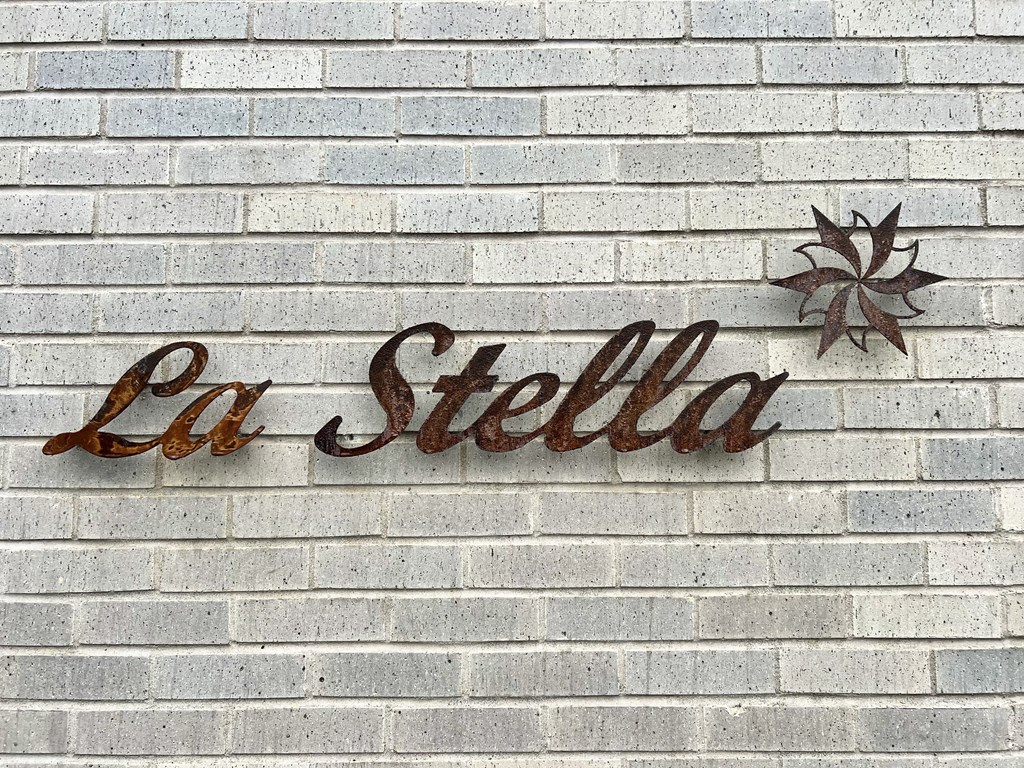 a sign on a brick wall that reads la stella