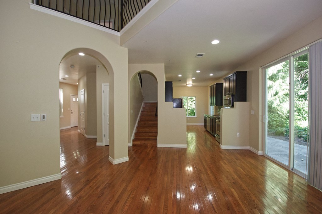 a living room with a hard wood floor and a staircase