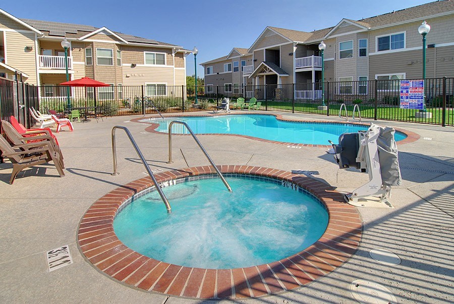 a hot tub in a pool next to an apartment building