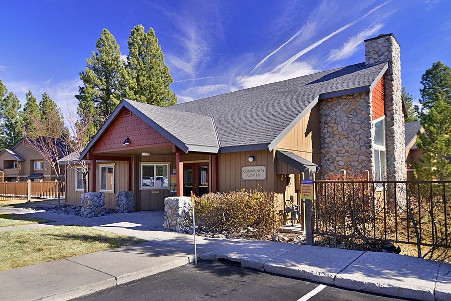a building with a stone chimney and a wood and stone building behind it