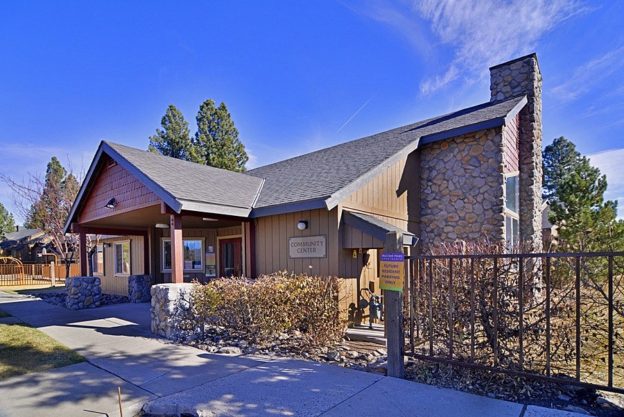 a building with a stone chimney and a wooden fence in front of it