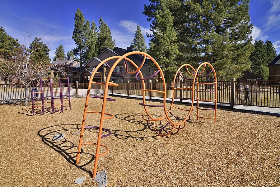 a swing set in a park with a house in the background