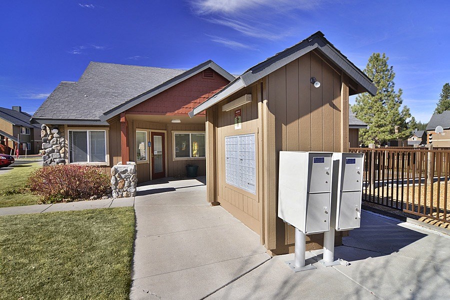 a small brown building with two mailboxes in front of it