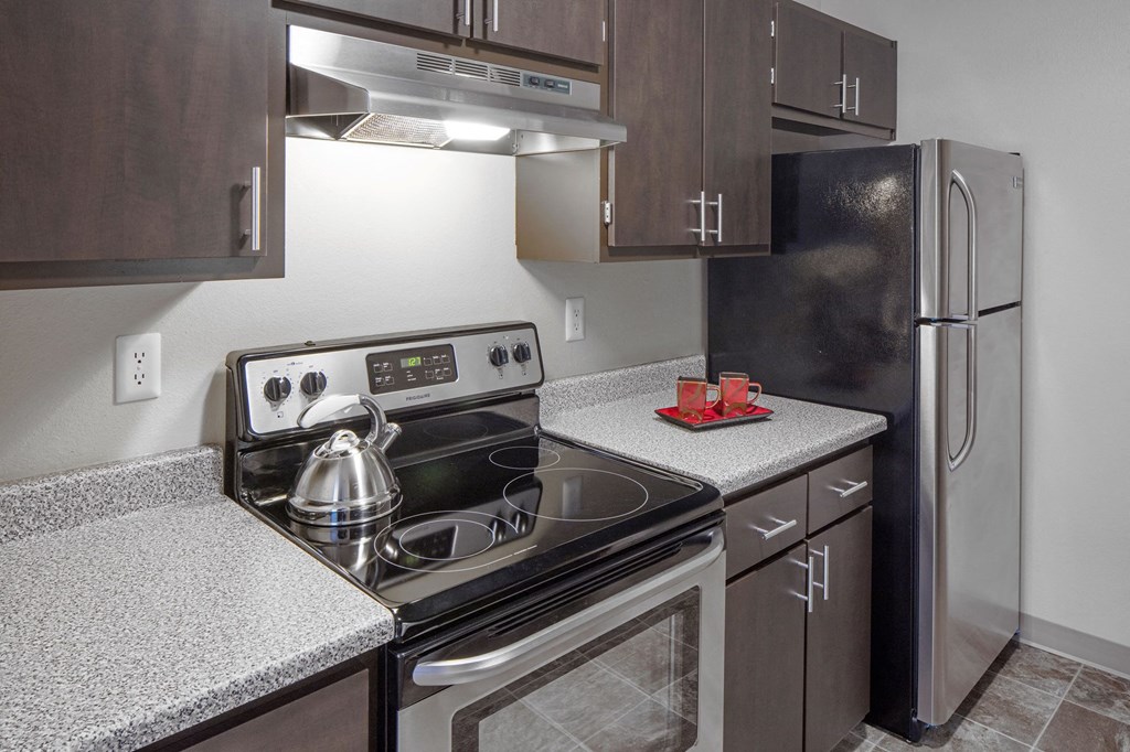 a kitchen with wood cabinets and stainless steel appliances