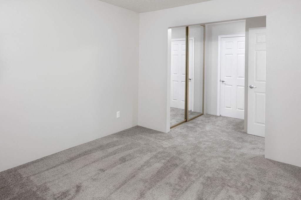 a bedroom with white walls and a carpeted floor