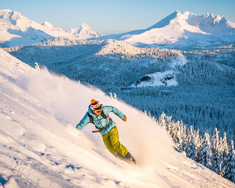 a man riding a snowboard down a snow covered slope