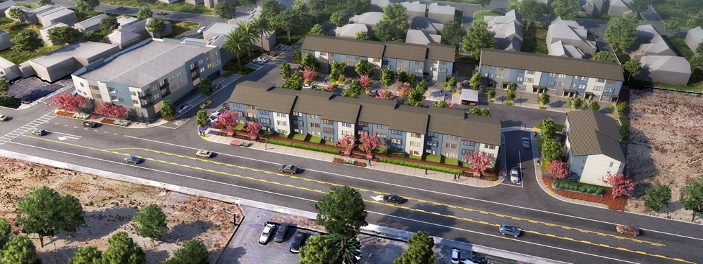 an aerial view of a row of houses with trees in front of them