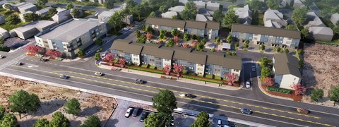 an aerial view of a row of houses with trees in front of them