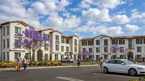 A row of apartment buildings with people walking in front.