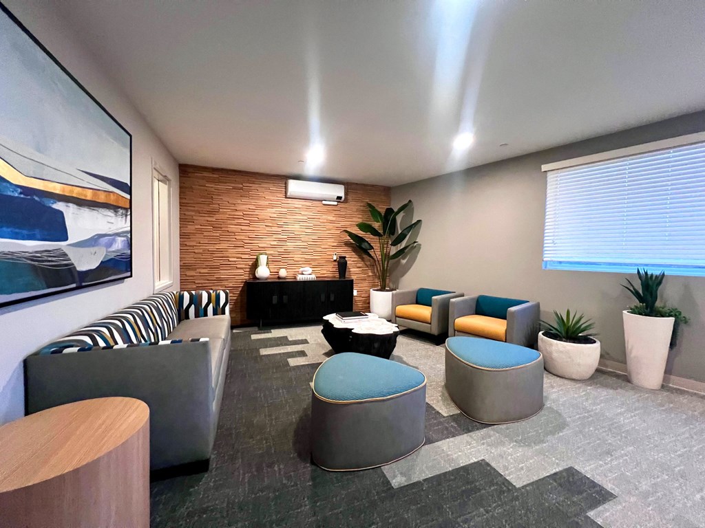 a lounge room with couches and chairs and a large window