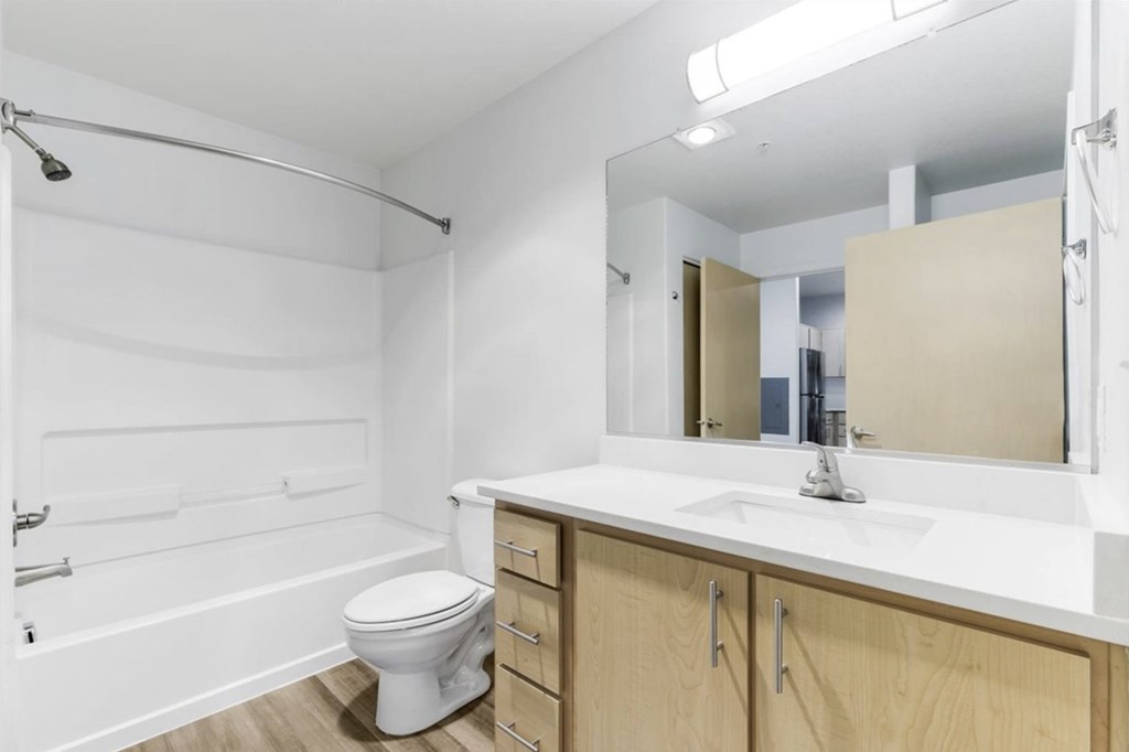 A white bathroom with a toilet, sink, and bathtub.