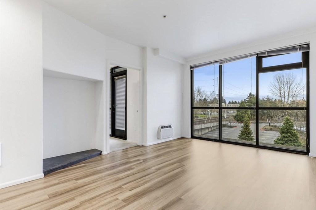 A room with a sliding glass door and a wooden floor.