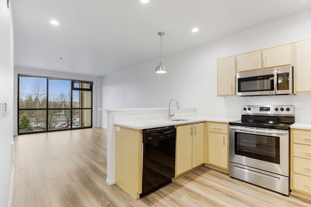 A kitchen with a stove top oven and microwave above it.