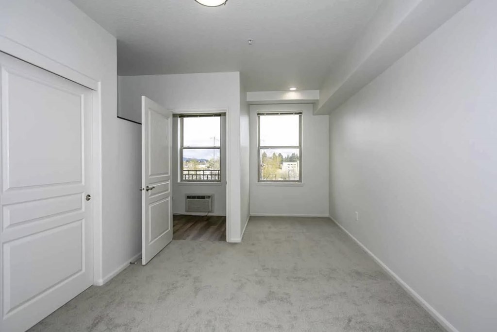 A white room with a door and a window.