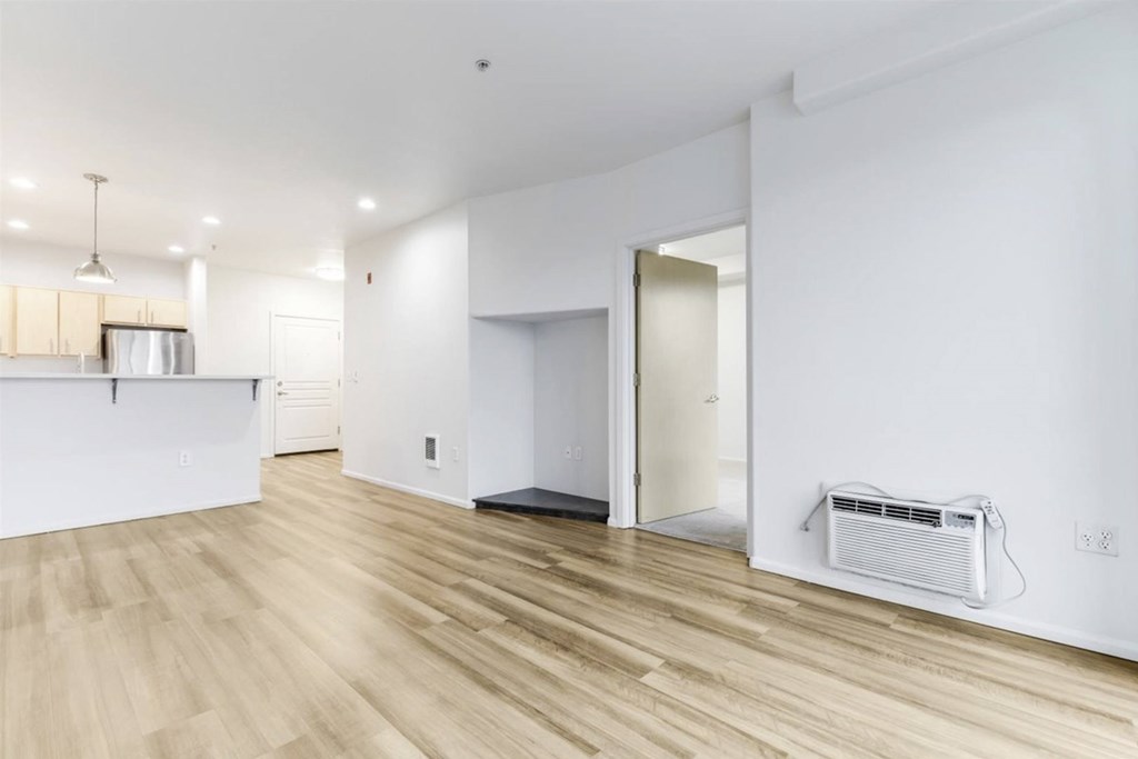 A room with a white wall and a wooden floor.