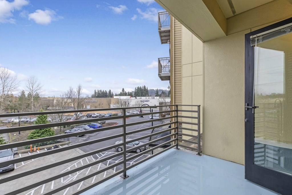 A balcony with a metal railing and a glass door.
