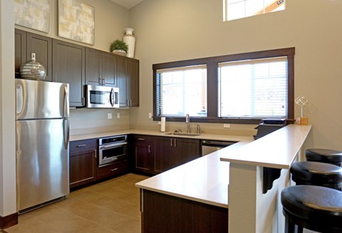 a large kitchen with stainless steel appliances and a white counter top