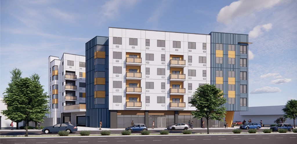 A modern multi-story building with balconies and a parking lot in front.