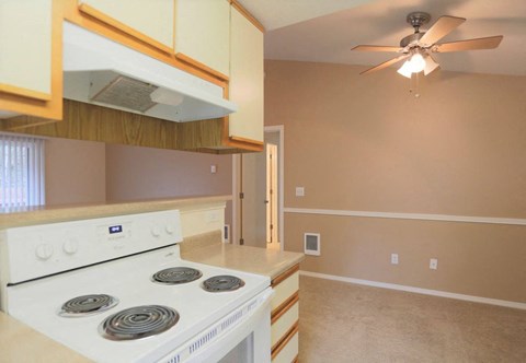 a kitchen with a stove and a ceiling fan