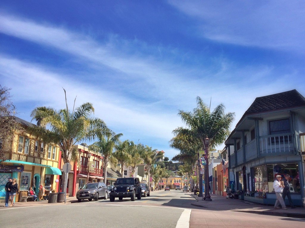 A street scene with cars and palm trees.