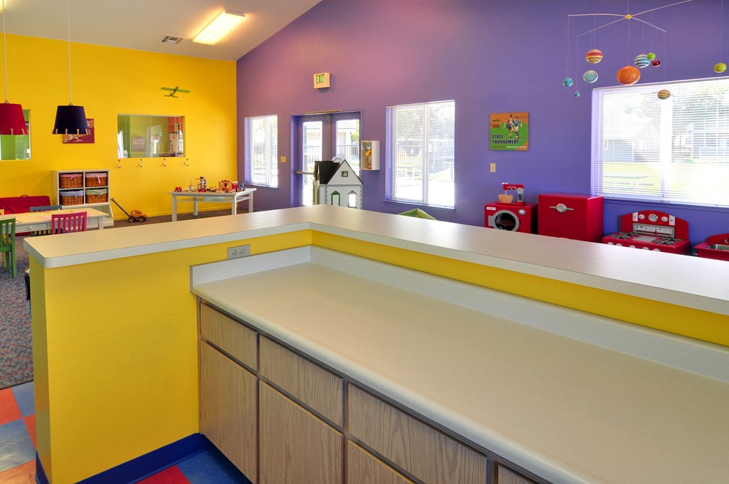 a childs play area with purple and yellow walls and a yellow and purple counter top