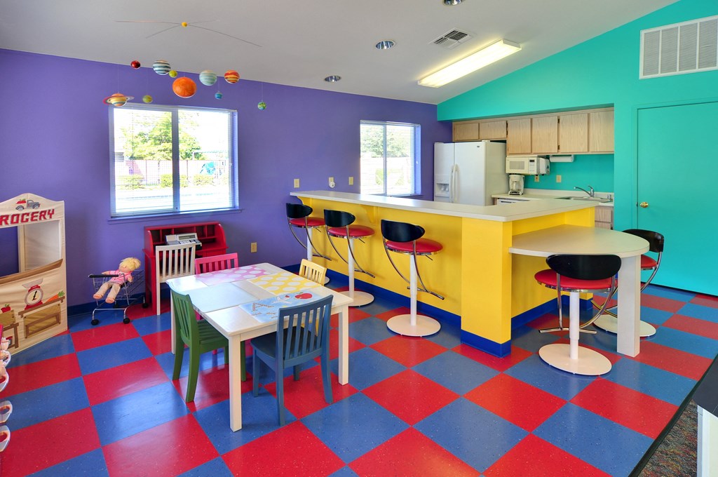 a room with a table and chairs and a kitchen