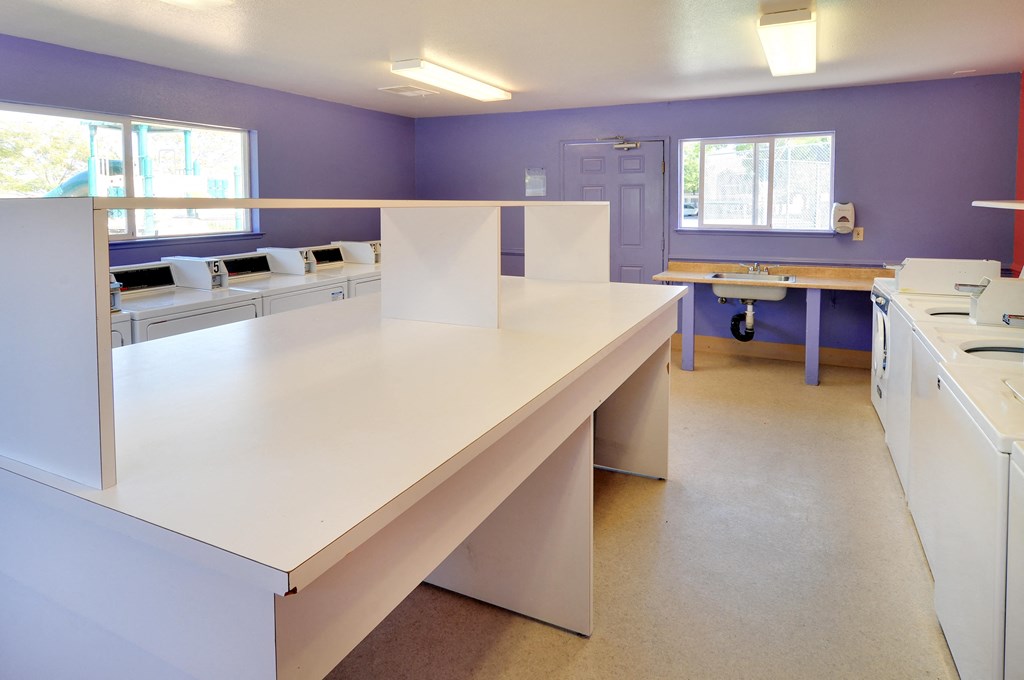 an office space with a desk and a sink