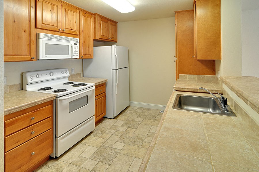 a kitchen with white appliances and wooden cabinets