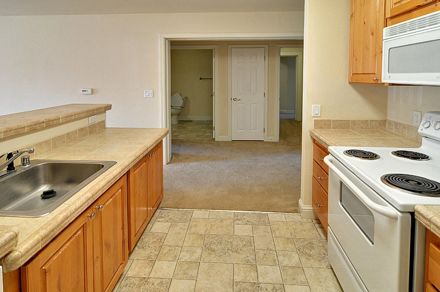 a kitchen with white appliances and wooden cabinets