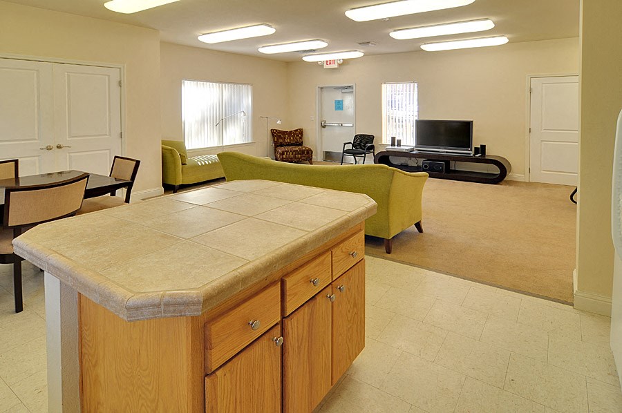 a kitchen with an island in the middle of it and a living room in the background