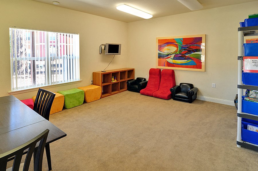 a living room with a tv and a table and chairs