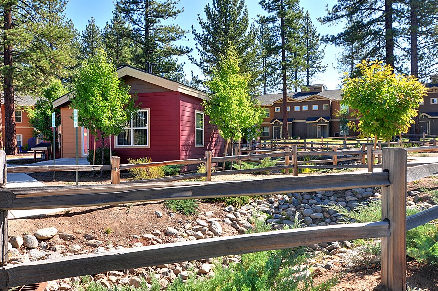 a red house with a wooden fence in front of it