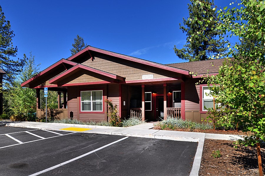 a red building with a porch and a parking lot