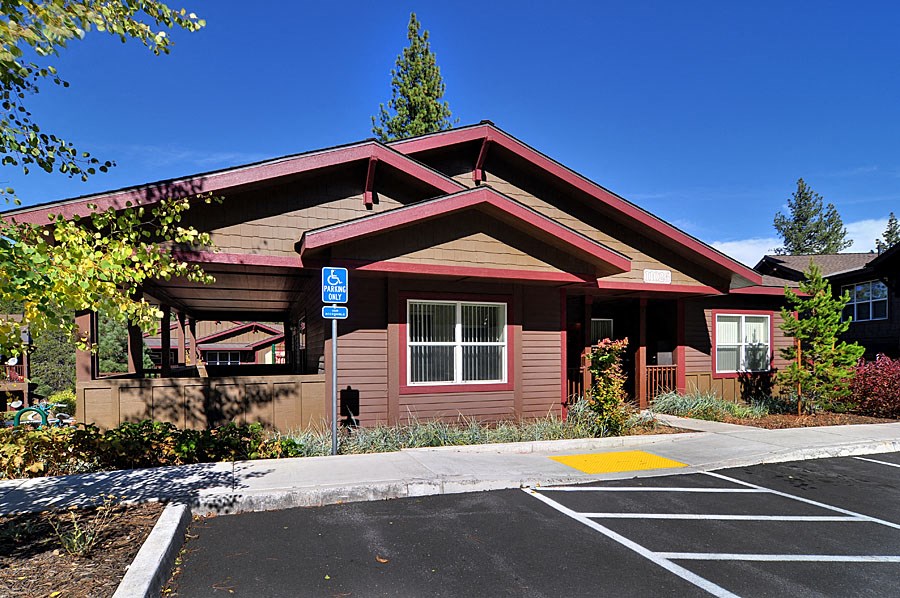 a red building with a parking lot and a street sign