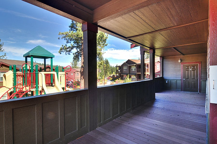 a porch with a view of a playground and a house